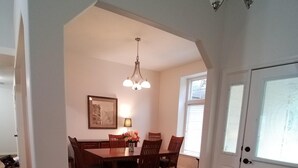 A dining area with a wooden table and chairs, a chandelier, and a rug. - Eagle ~ Great Sky Neighborhood ~ 4-Bdrms  ~ Near Pool & Shopping ~ ALL Amenities (Eagle)