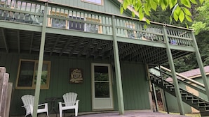 A green wooden building with a balcony, two Adirondack chairs, and a sign that says "Home is where the mountains are." - 2 min WALK to BEACH!Summer Escape!Relax,hike,swim,shop...NConway/Eidelweiss. (Madison)