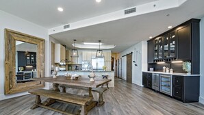 A spacious kitchen with a large wooden table, dark cabinetry, and a mirrored wall. - PENTHOUSE DPH14:  3BR/3BA Sleeps 8 Amazing views and amenities (Orange Beach)