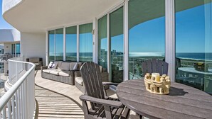 A balcony with wicker furniture, a round table, and a decorative sculpture. - PENTHOUSE DPH14:  3BR/3BA Sleeps 8 Amazing views and amenities (Orange Beach)