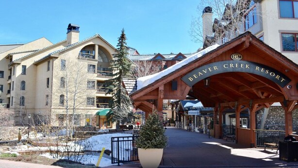 The entrance to Beaver Creek Resort with a covered walkway, a large planter, and a view of the surrounding buildings. - LUXURIOUS AND SPACIOUS CONDO ,SKI IN/ SKI OUT IN BEAVER CREEK, COLORADO. (Avon)