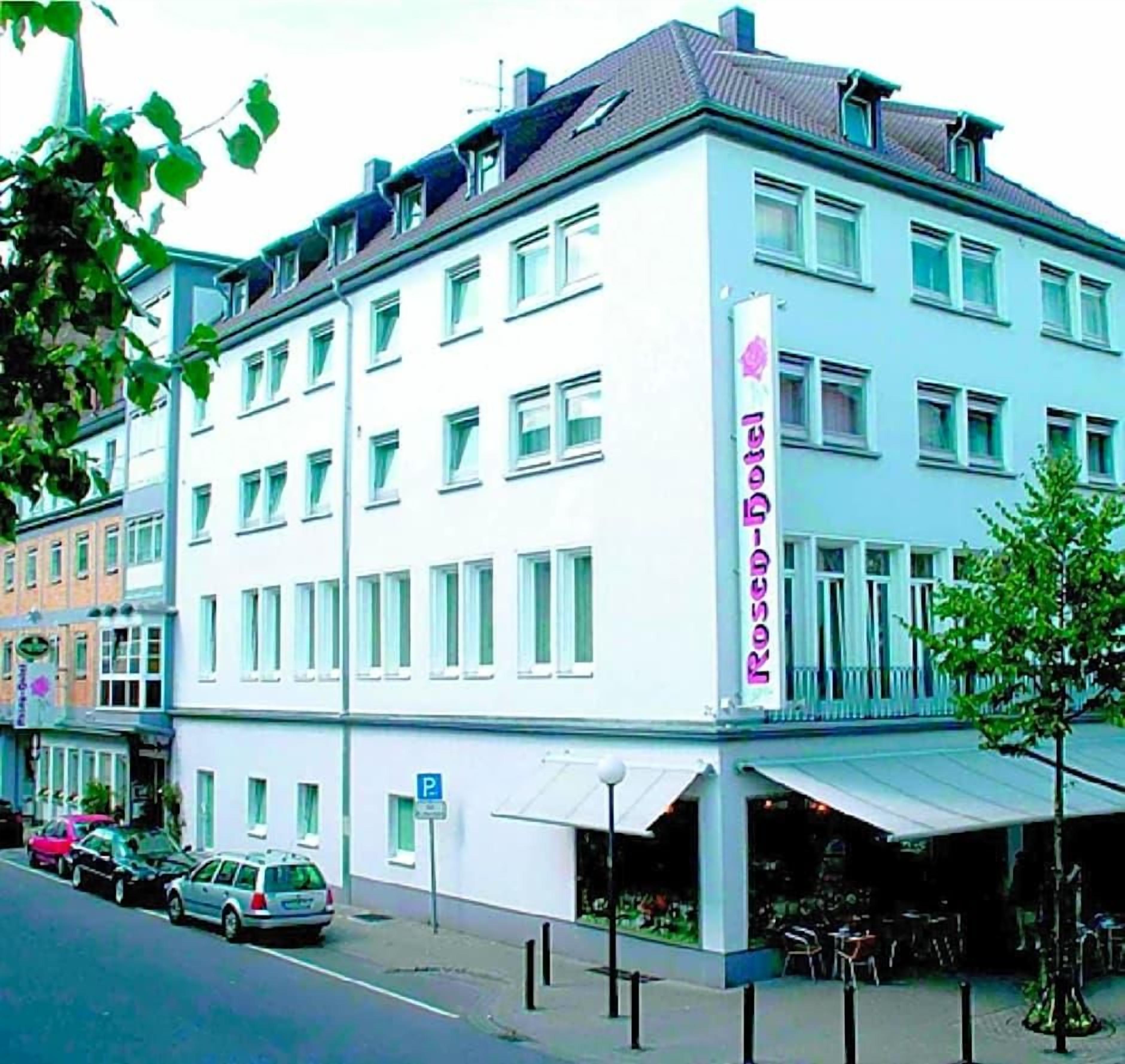 Ein mehrstöckiges Gebäude mit Restaurant im Erdgeschoss, einem Parkschild und Blick auf die Straße.