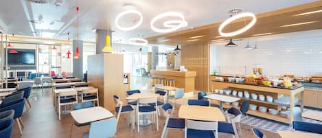A modern cafe with round tables and chairs, a breakfast bar, and a view of the street.