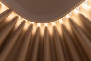 Eine Decke mit einer Reihe paralleler Linien, die ein Muster aus Licht und Schatten bilden.