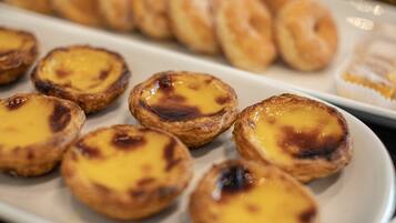 A plate of small, round pastries with a golden-brown crust and a creamy filling.