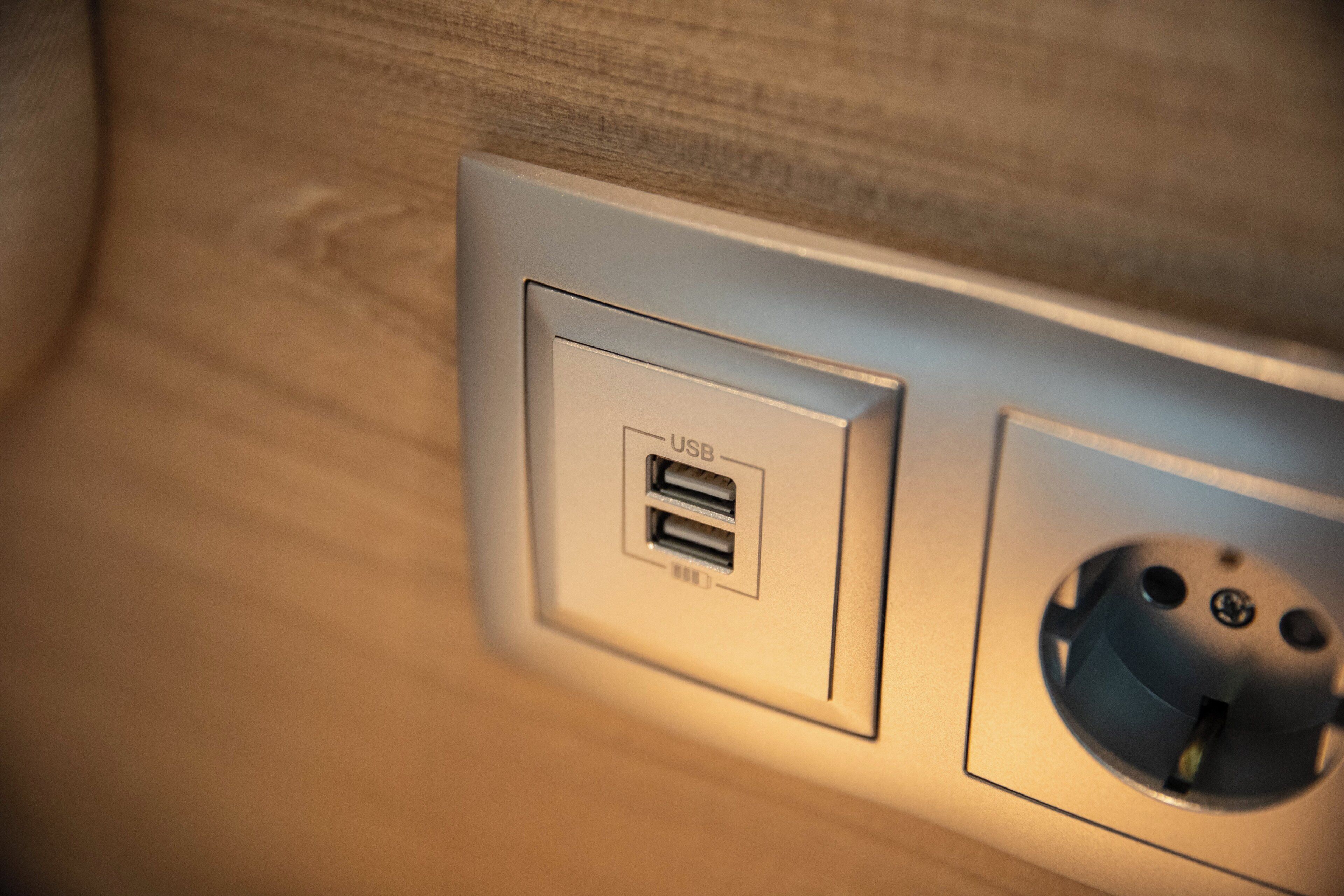 Un enchufe eléctrico empotrado en la pared con puerto USB y toma corriente estándar.
