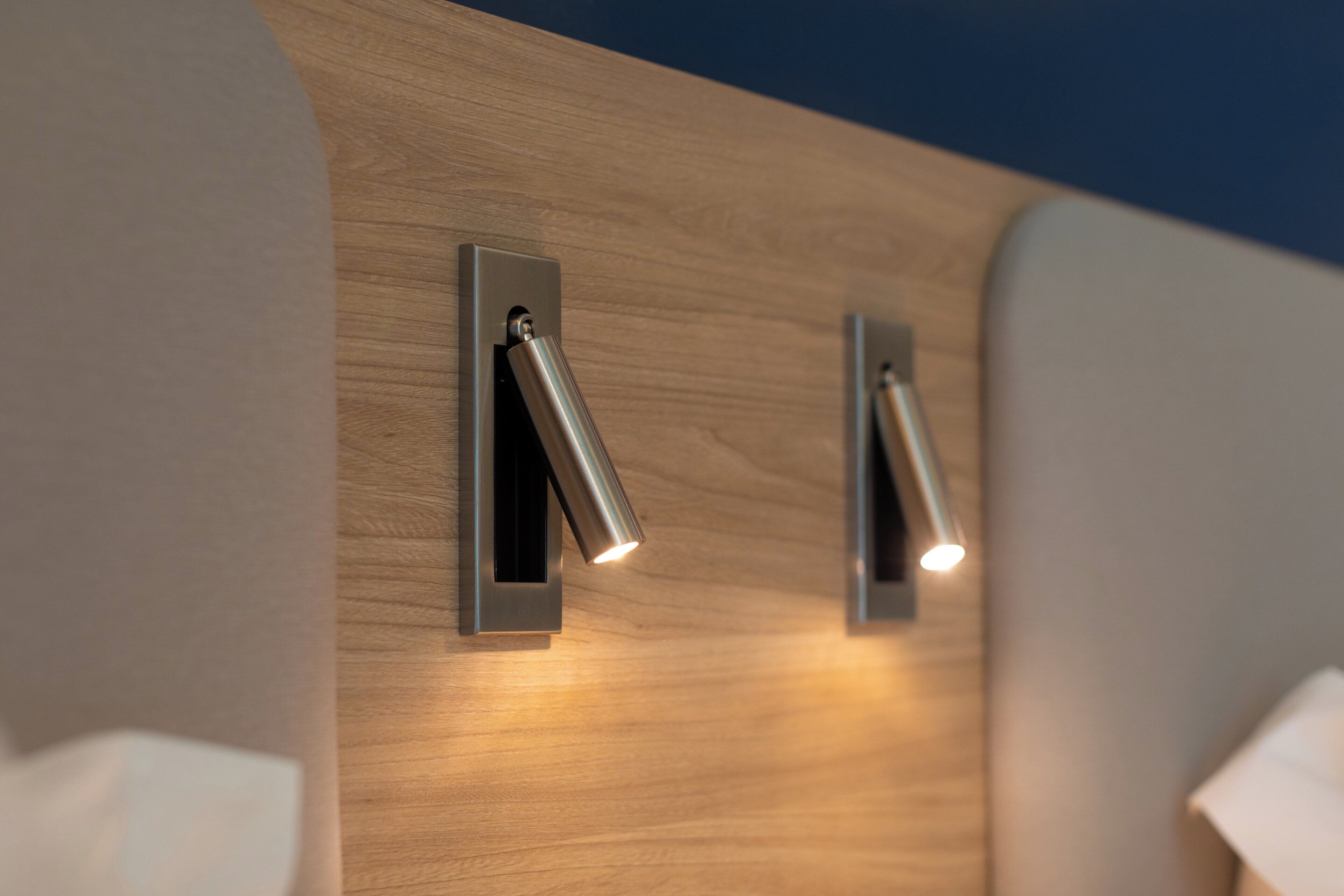 A modern wall with two recessed lighting fixtures.