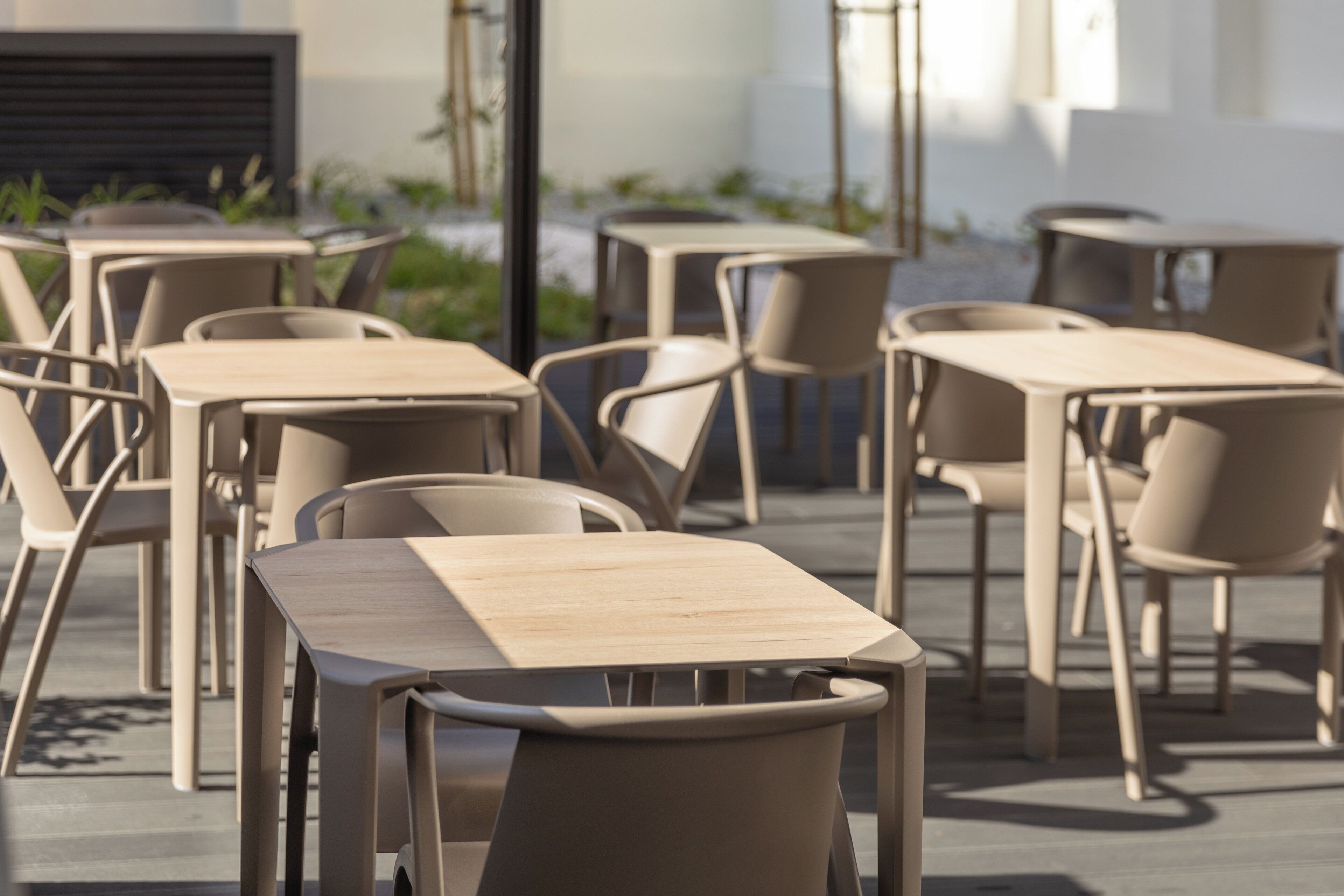 Un espace extérieur aménagé avec plusieurs tables et chaises.