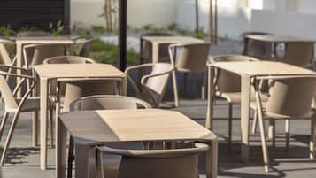 Un espace extérieur aménagé avec plusieurs tables et chaises.