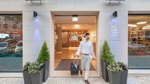 Ein Hotel Eingang mit modernem Design, inklusive einer Rezeption und einem gut sichtbaren Schild für 'Holiday Inn Express Lisboa Saldanha'.