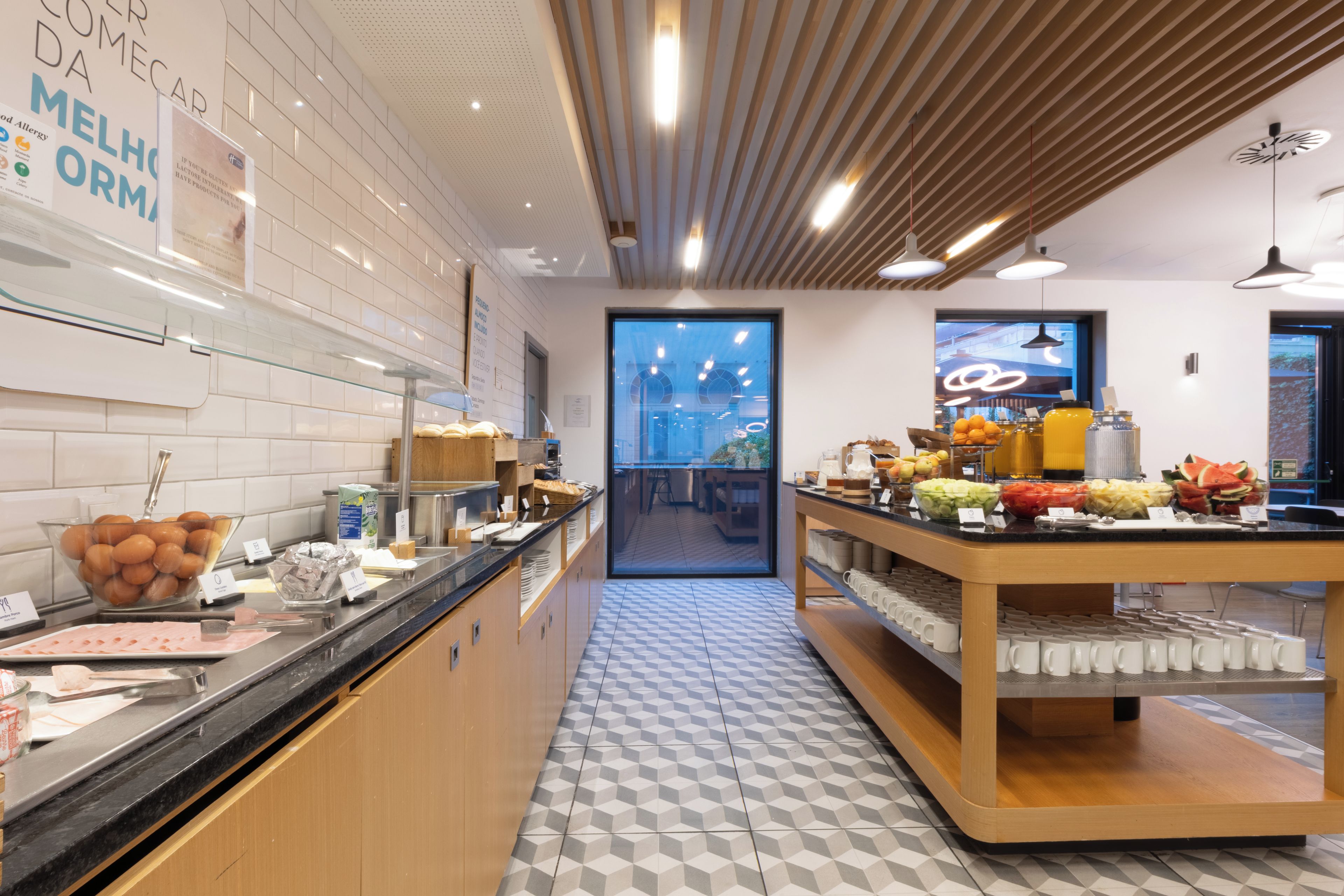 A modern breakfast area with a variety of food options and a clean, geometric tile floor.