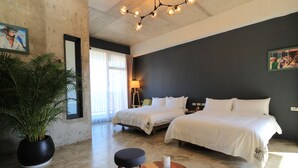 A hotel room with two beds, a large potted plant, a small round table, and a modern chandelier. - Comesit (Xincheng)