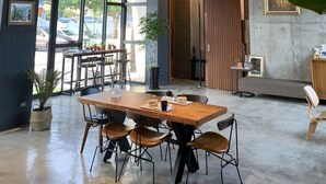 A spacious indoor area with a large table and chairs, a ceiling fan, and visible ductwork. - Comesit (Xincheng)