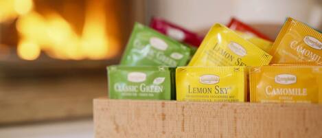 A wooden box containing various packaged snacks, including 'Classic Green' and 'Lemon Sky' flavors.