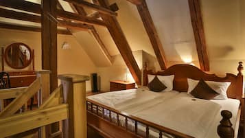 Un dormitorio con una cama de madera, una mesita de noche, una lámpara y una escalera de madera.
