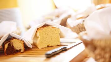 A loaf of bread and a knife on a wooden surface.