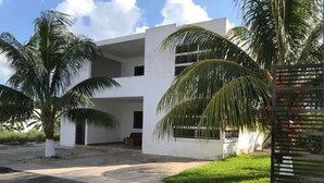 A modern two-story building with a flat roof, surrounded by palm trees and a paved driveway. - 330 Hotel Altabrisa (Mérida)
