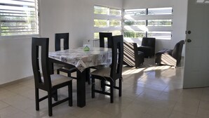 A dining area with a table and chairs, a ceiling fan, and windows with blinds. - 330 Hotel Altabrisa (Mérida)