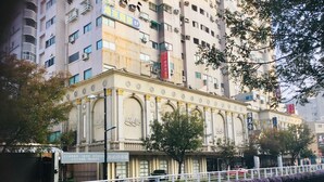 A multi-story building with classical architecture, featuring arched windows and decorative moldings. - Hone Lane Business Hotel (Kaohsiung)