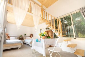 A bedroom with two beds, a dining table, and a large window. - Water House (Dahu)