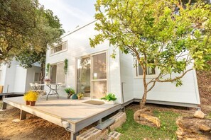 A modern house with a patio, a dining area, and a small garden. - Water House (Dahu)