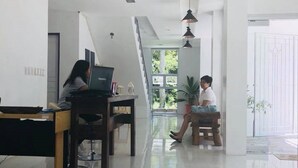 A spacious living area with a high ceiling, a dining table, and a sofa. - Hotel Lady Nina (Baler)