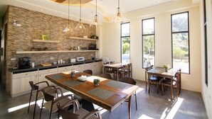 A modern kitchen with a wooden island, built-in appliances, and large windows offering a view of the outdoors. - Hu An-The Lakeside House (Yuchi)