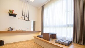 A modern room with a wooden bench, a small table, and a hanging light fixture. - Hu An-The Lakeside House (Yuchi)