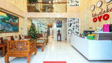 A lobby with a reception desk, a Christmas tree, and a 'Welcome' mat.