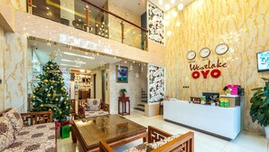 Eine Hotelhalle mit Weihnachtsbaum, Rezeption und einer Sitzecke mit Glastisch.