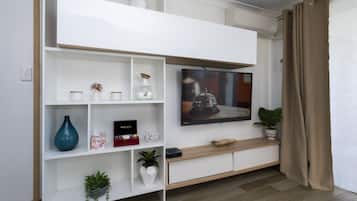 Apartamento exclusivo, 2 quartos, para não fumantes, vista para a praia | Área de estar | TV de tela plana 55 polegadas com canais de TV premium, smart TV