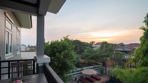 A balcony with a pool, lounge chairs, and a table with a decorative bowl.