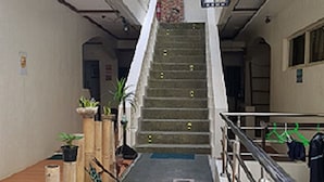 Eine Treppe, die zu einer oberen Etage führt, gesäumt von Topfpflanzen und mit einem Geländer versehen.