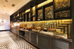 Un bar d’hôtel moderne avec un mur décoré de motifs, un comptoir en marbre et un sol à motifs.