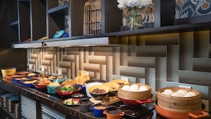 Un bufé con diferentes opciones de comida y una pared decorativa.