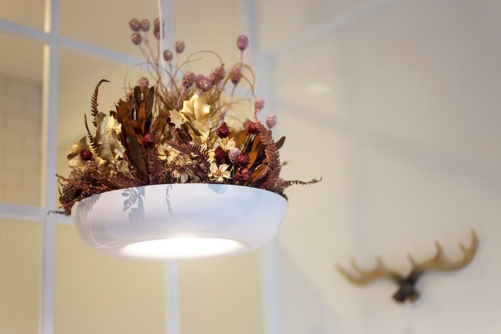 A chandelier with dried foliage and flowers.