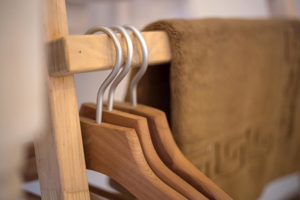 Ein Kleiderständer aus Holz mit mehreren Kleiderbügeln.