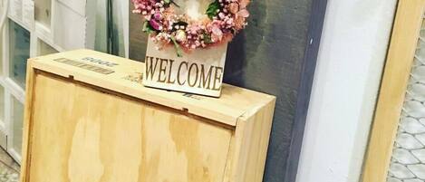 Un letrero de madera con un arreglo floral encima, colocado sobre una caja de madera que dice "RUPERT & ROTHSCHILD VIGNERONS".