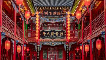A traditional Chinese building with red and green decorations, a sign for the Long Ji Long Hotel, and multiple red lanterns.