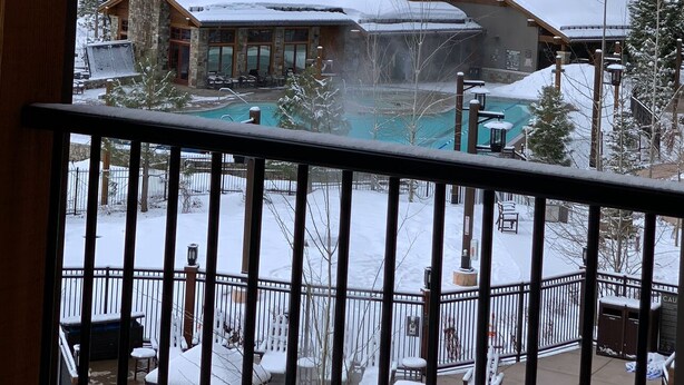Un resort con diversi edifici, una piscina e un paesaggio innevato.