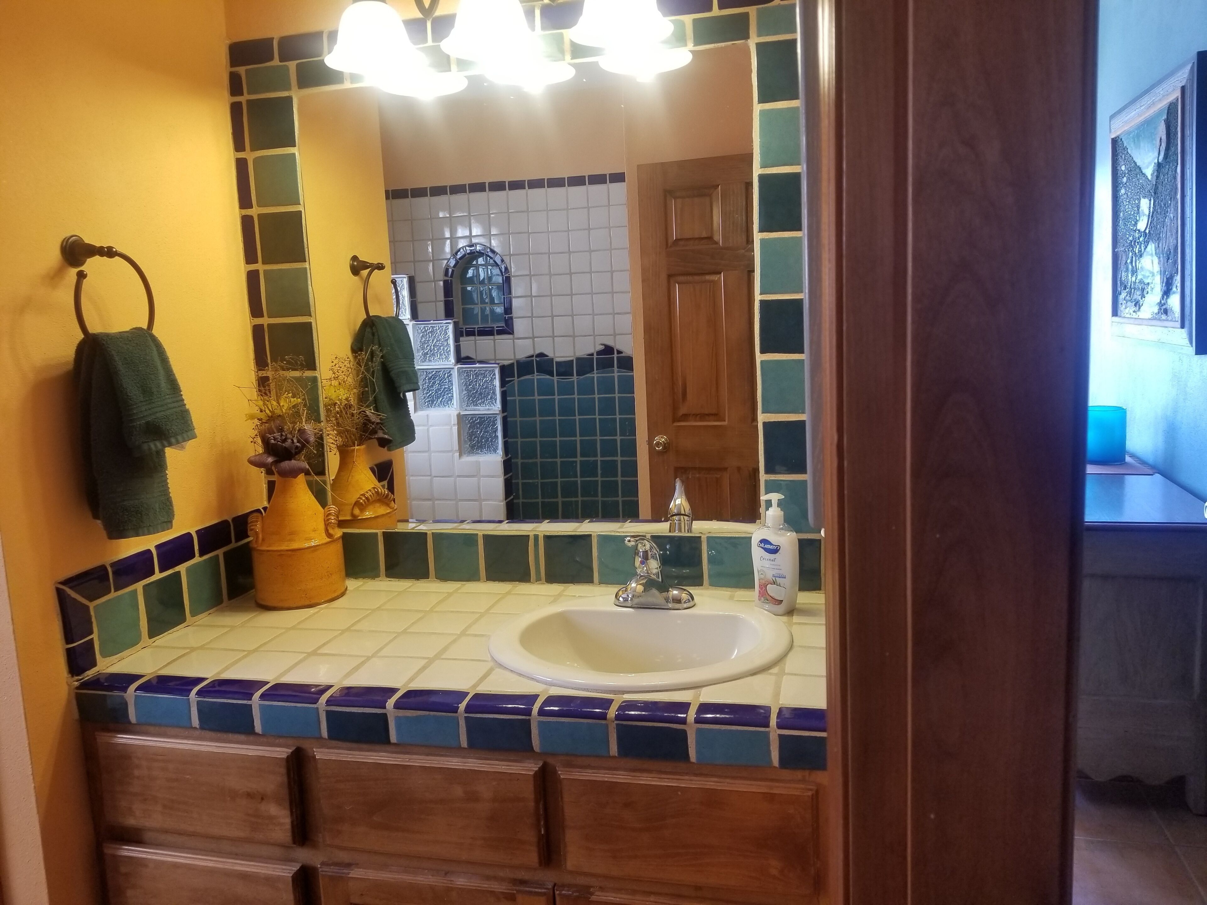 Une salle de bain équipée d’un lavabo, d’un miroir et d’un porte-serviettes.
