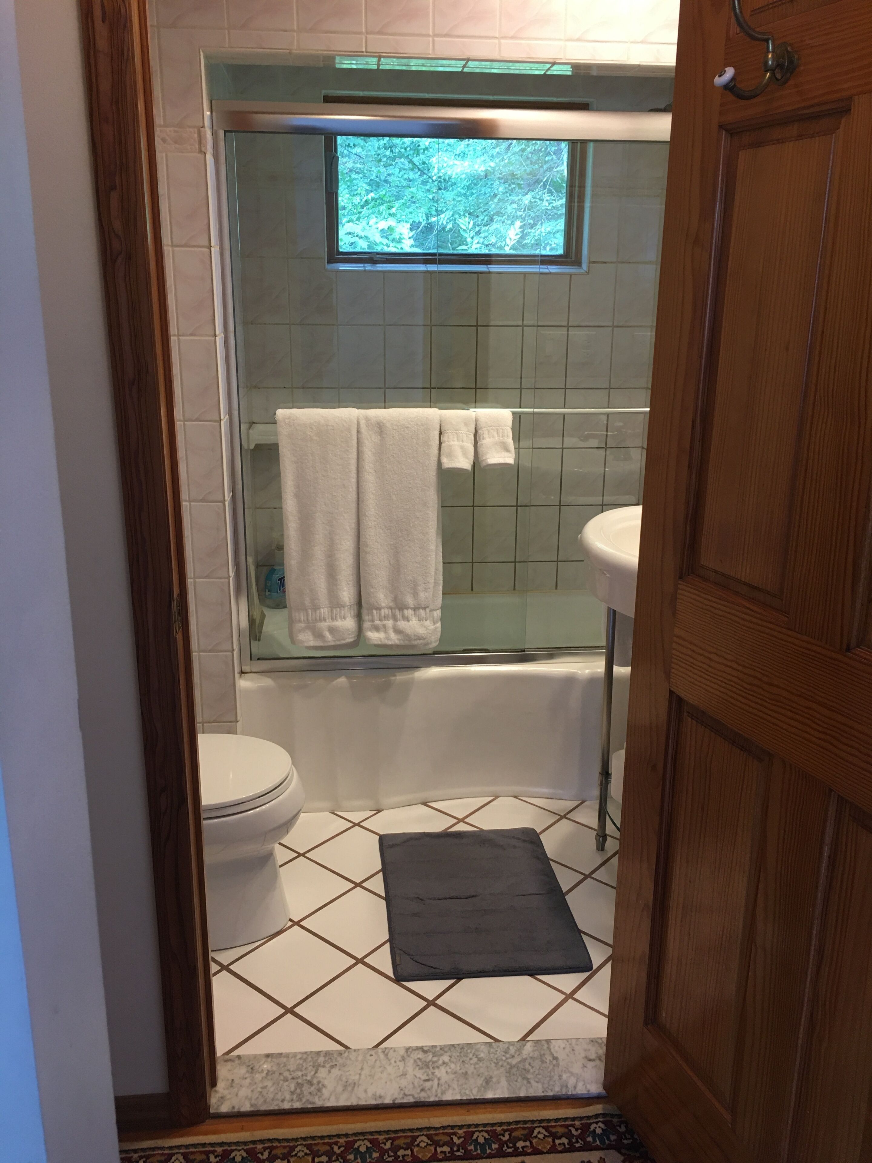 Een bad/douchecombinatie, handdoeken, zeep, toiletpapier