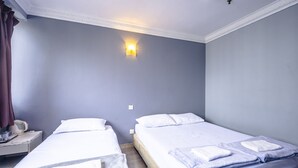 A hotel room with two single beds, a nightstand, a lamp, and a wall-mounted light fixture. - K HOTEL 12 (Singapore)