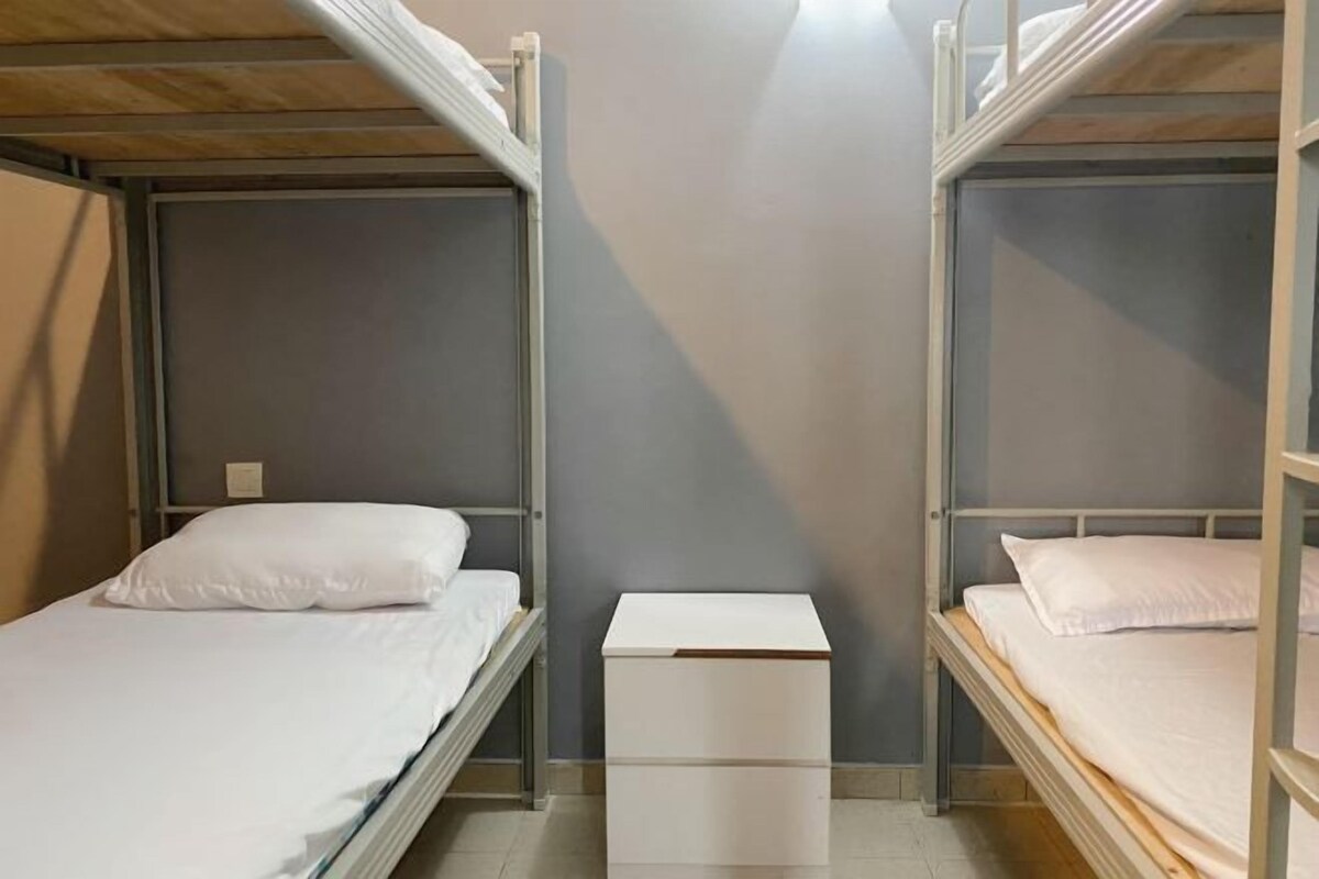 Habitación con literas y un armario blanco en el centro.