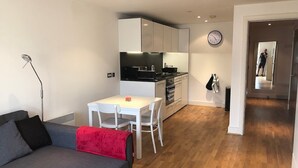 A compact living space with a kitchenette, a dining area, and a sofa. - Toothbrush Apartments - Ipswich Quayside (Ipswich)