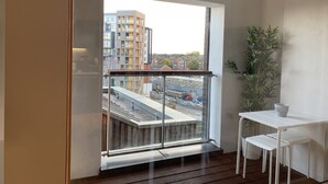 A modern room with a large window, a small table, and a potted plant. - Toothbrush Apartments - Ipswich Quayside (Ipswich)