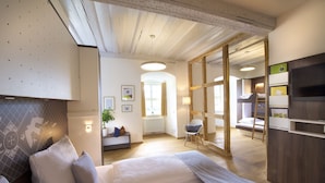 Una habitación de hotel moderna con una cama grande, un escritorio y vistas de la habitación contigua.