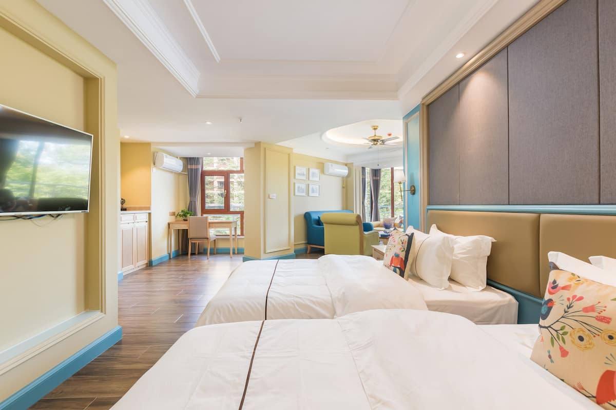 deluxe suite, garden view | in-room safe, desk, blackout curtains, iron/ironing board