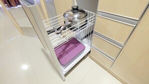 A kitchen with a built-in oven and a stainless steel pot rack. - Comfortable and Modern Studio Apartment near Cawang and MT Haryono (Jakarta)