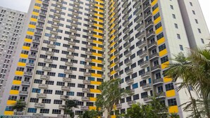 A high-rise residential building with multiple balconies and a uniform facade. - Modern and Comfortable Studio Apartment Springlake Summarecon near Summarecon (Bekasi)